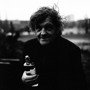 Emir Kusturica holding a bottle of alcohol.