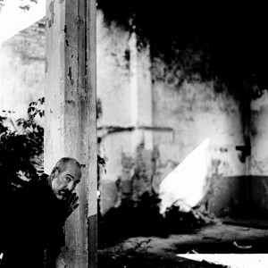 Jean-Marc Barr posing at a pillar in an old ruined house.