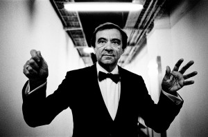 Marcello Rota wearing a tuxedo making gesture conducting without a baton. 