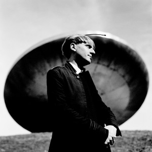Neil Harbisson standing at a monument of ufo spaceship.