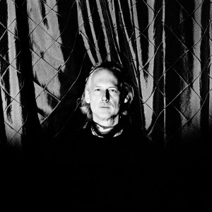 Richard Dorfmeister in front of a checked curtain.
