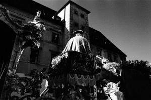 Robert Dornhelm pouring water from a bottle on his head at a historical chariot with coachman in historical costume.